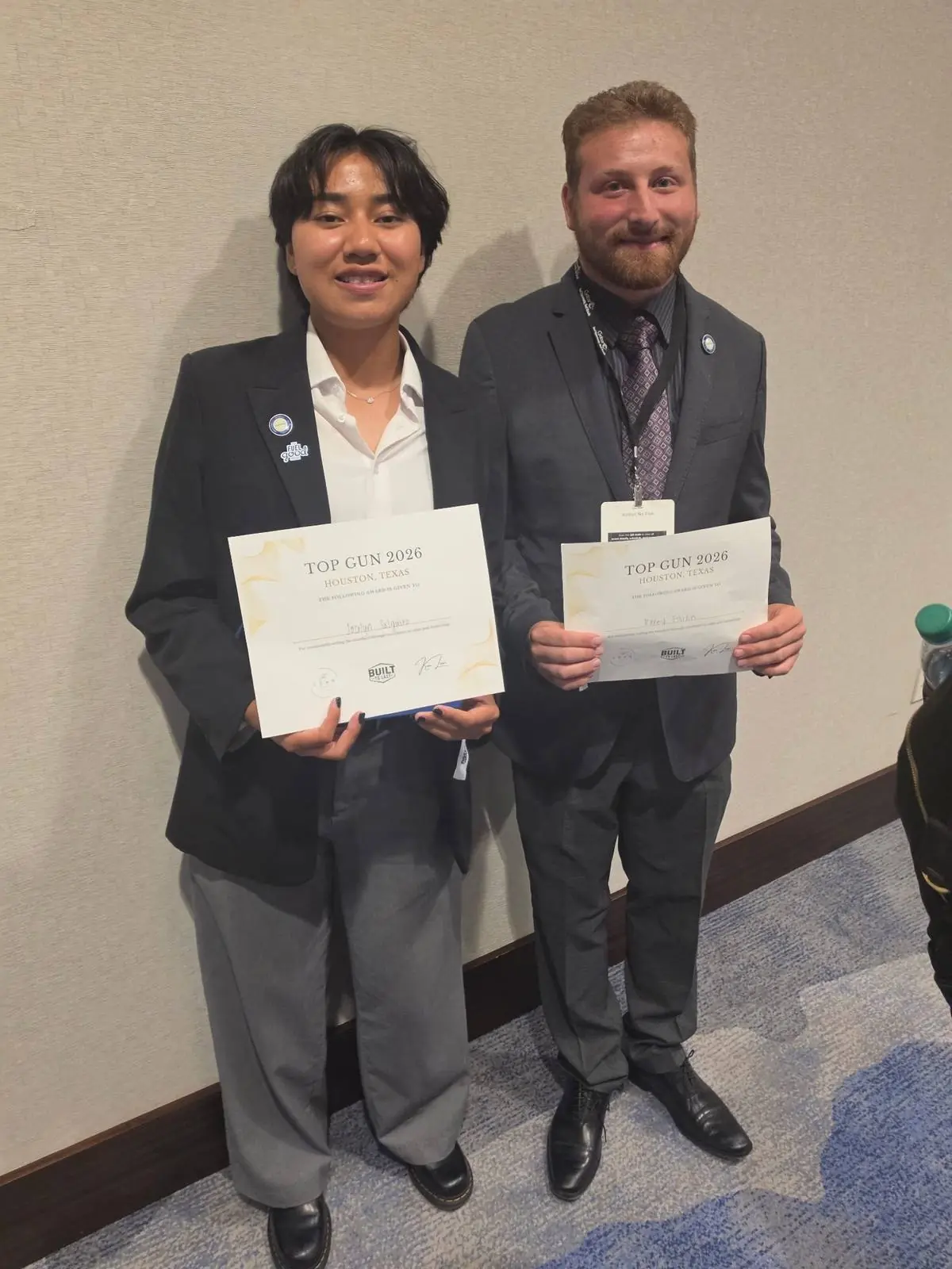 Two team members holding their Top Gun 2026 awards in Houston, Texas